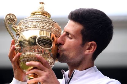 Novak Djokovic kisses the trophy at Wimbledon