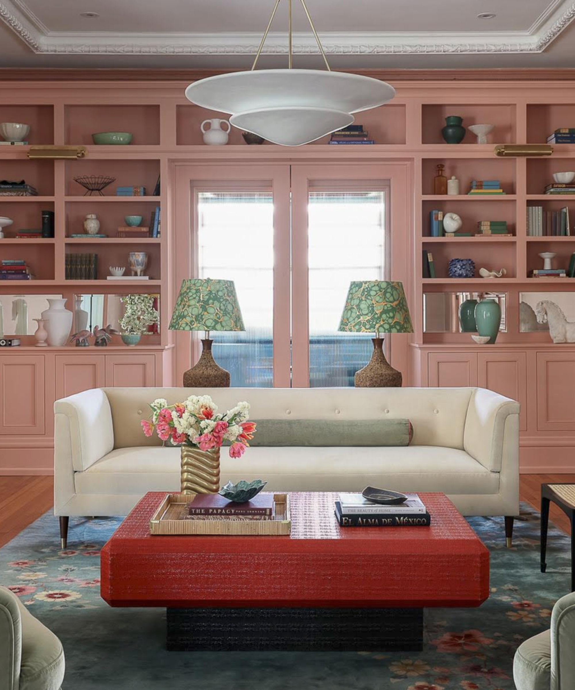 Pink living room with white tuxedo sofa