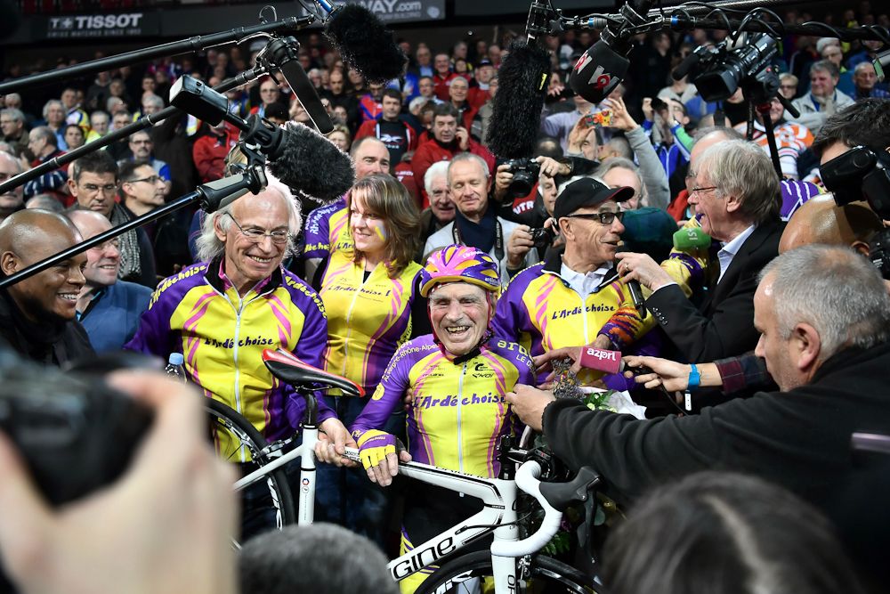 Fans surround Robert Marchand after setting a one-hour track cycling World record at 22.547km in the over-105 age group