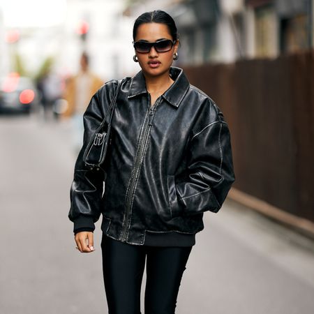 Street-style photo of a woman in a leather jacket, capri leggings, and kitten heels. 