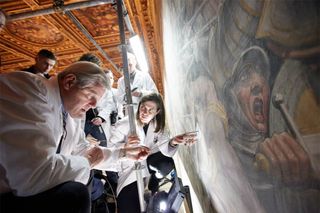 Terry Garcia of National Geographic (left), Leonardo project leader Maurizio Seracini (center) and Florence Mayor Matteo Renzi come together on the scaffolding next to the Vasari mural in Florence's Palazzo Vecchio.