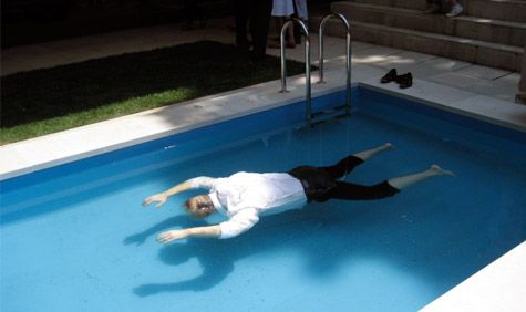 Man floating face down in a pool