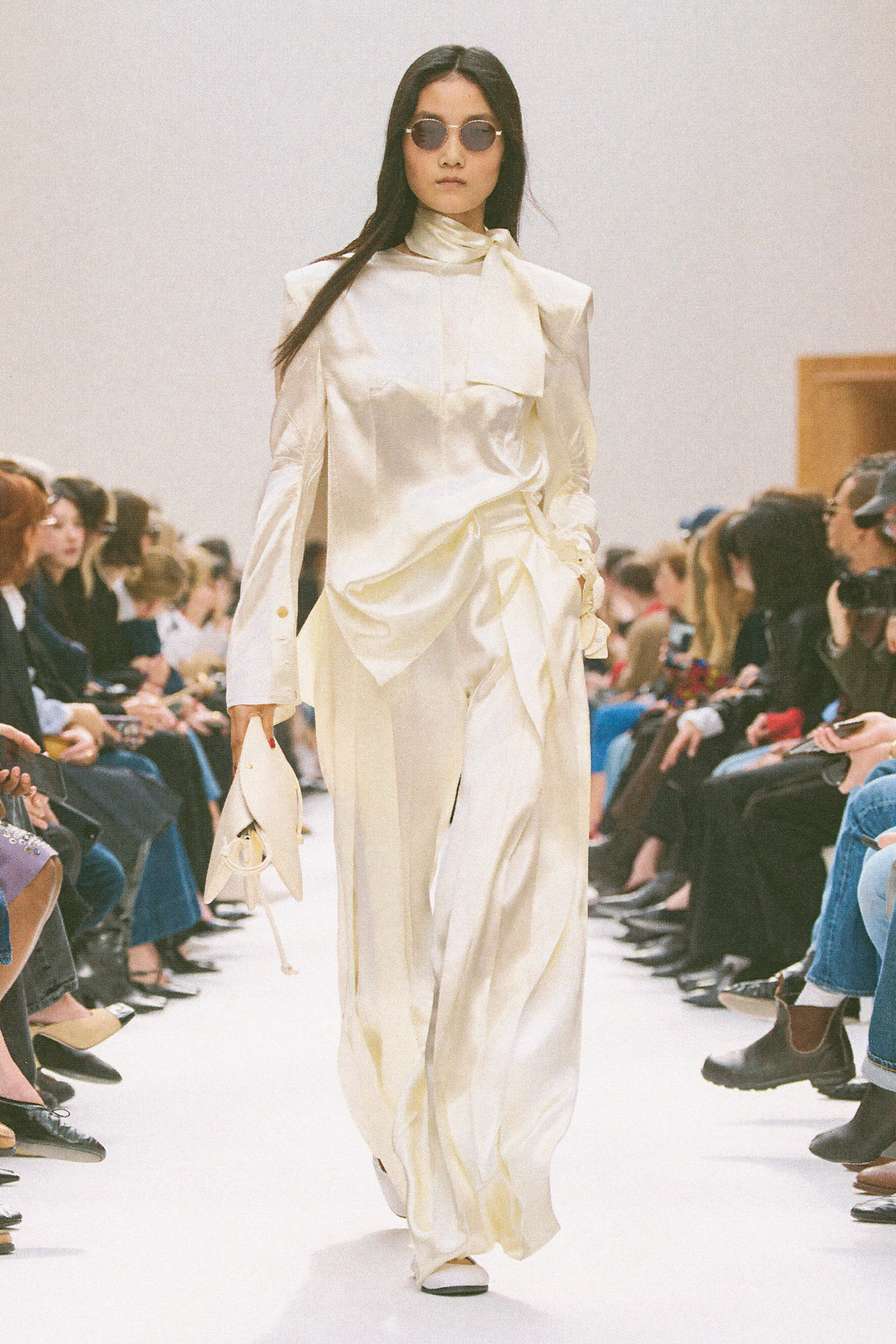 Runway model in a white satin outfit.