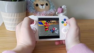 Hands holding Anbernic RG Cube with Crash Team Racing gameplay on screen