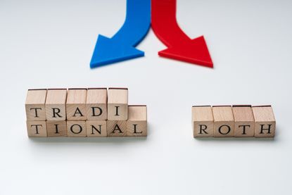 Red And Blue Directional Arrows Showing Traditional And Roth Options On Wooden Blocks.