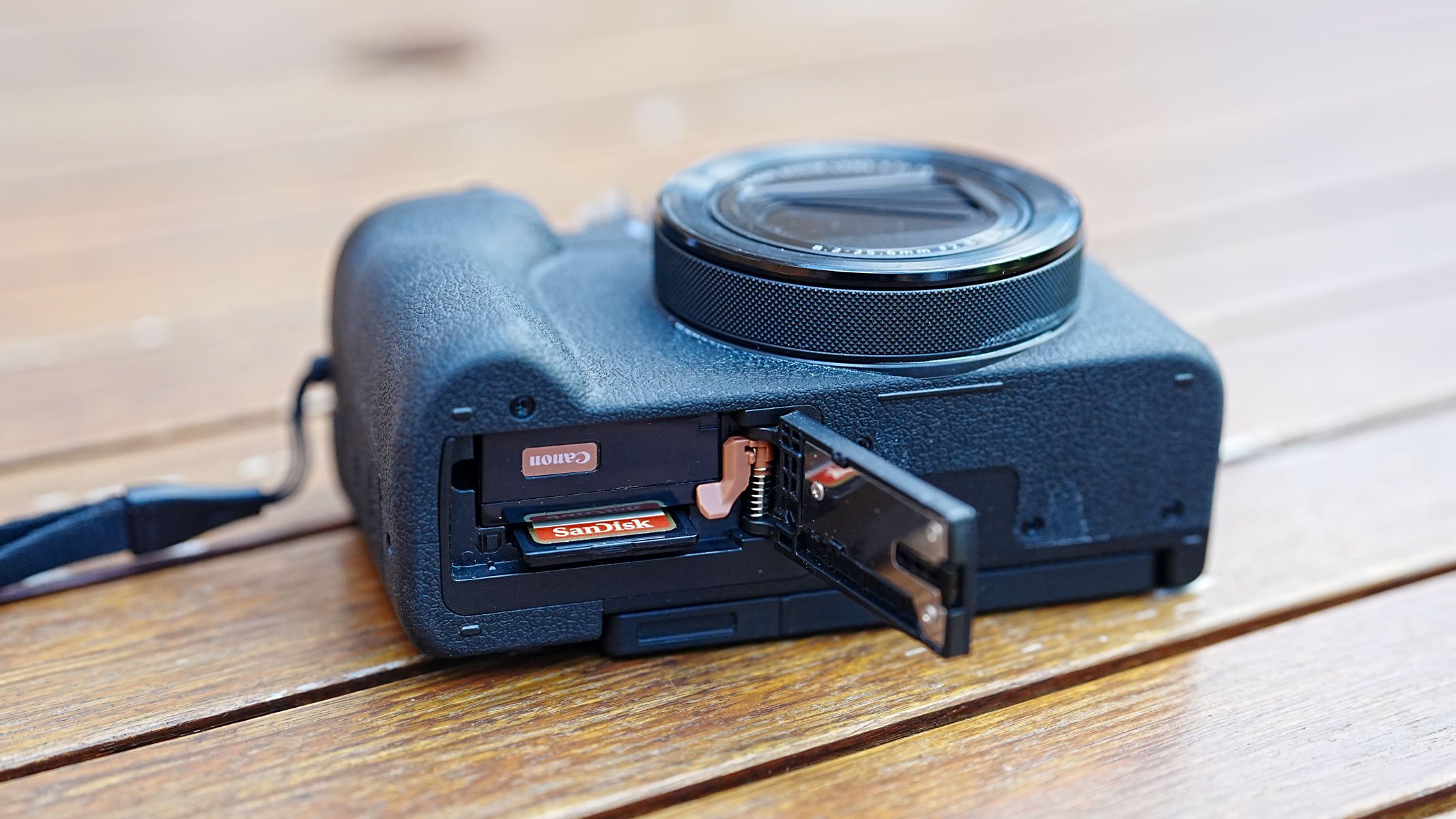 A Canon Powershot V1 with battery compartment open.