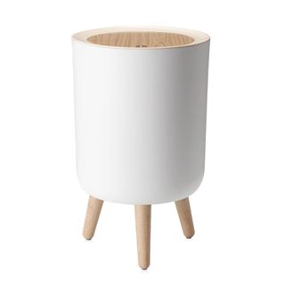 A white trash can on legs with wooden lid