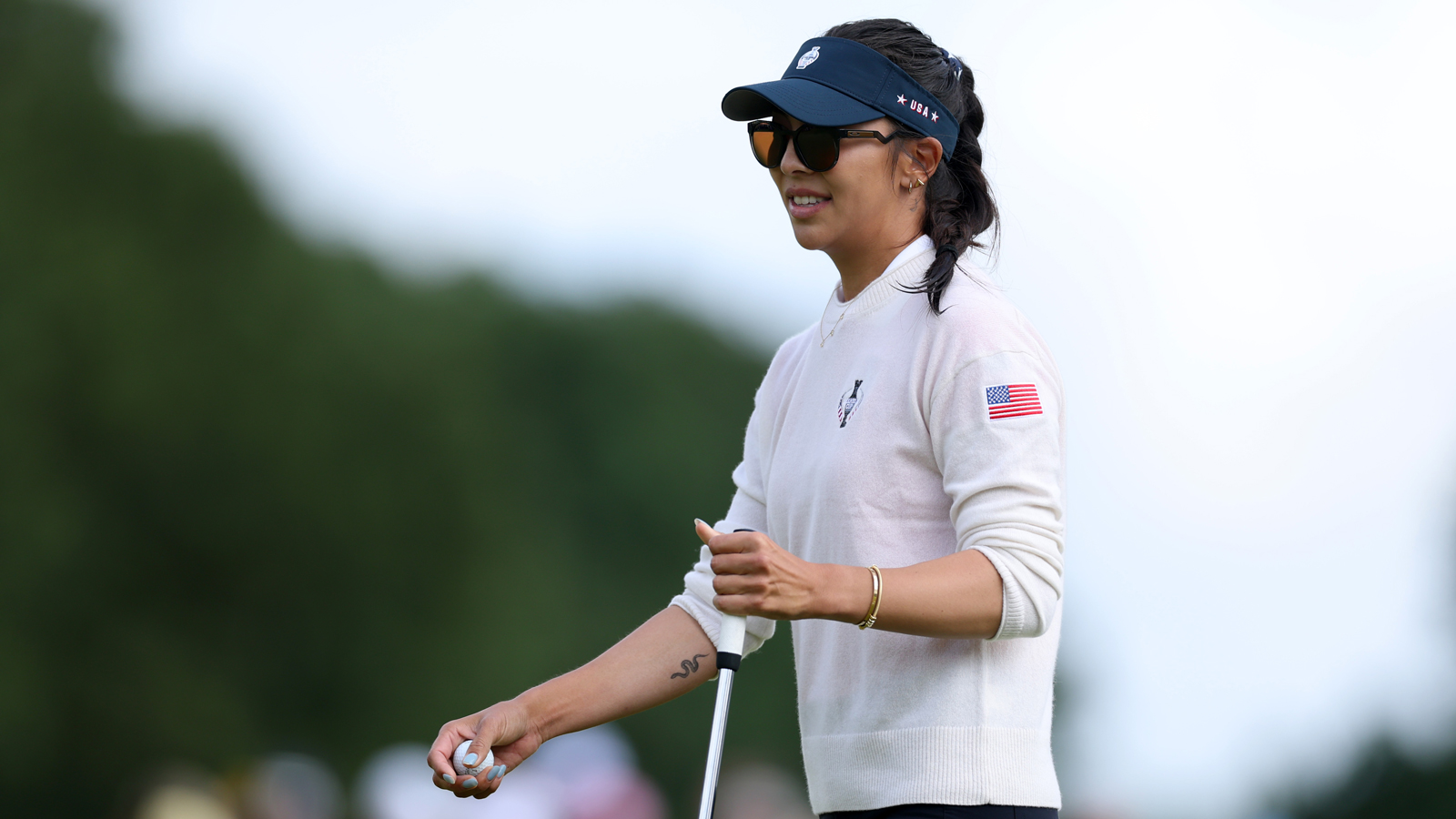 Alison Lee smiles while looking at a putt