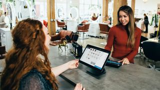 woman paying for service in a salon using a pos system