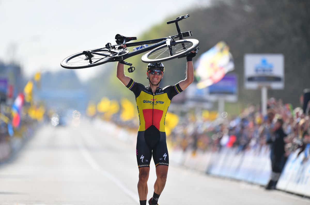 Philippe Gilbert (Quick-Step Floors) lifts his bike above his head in celebration