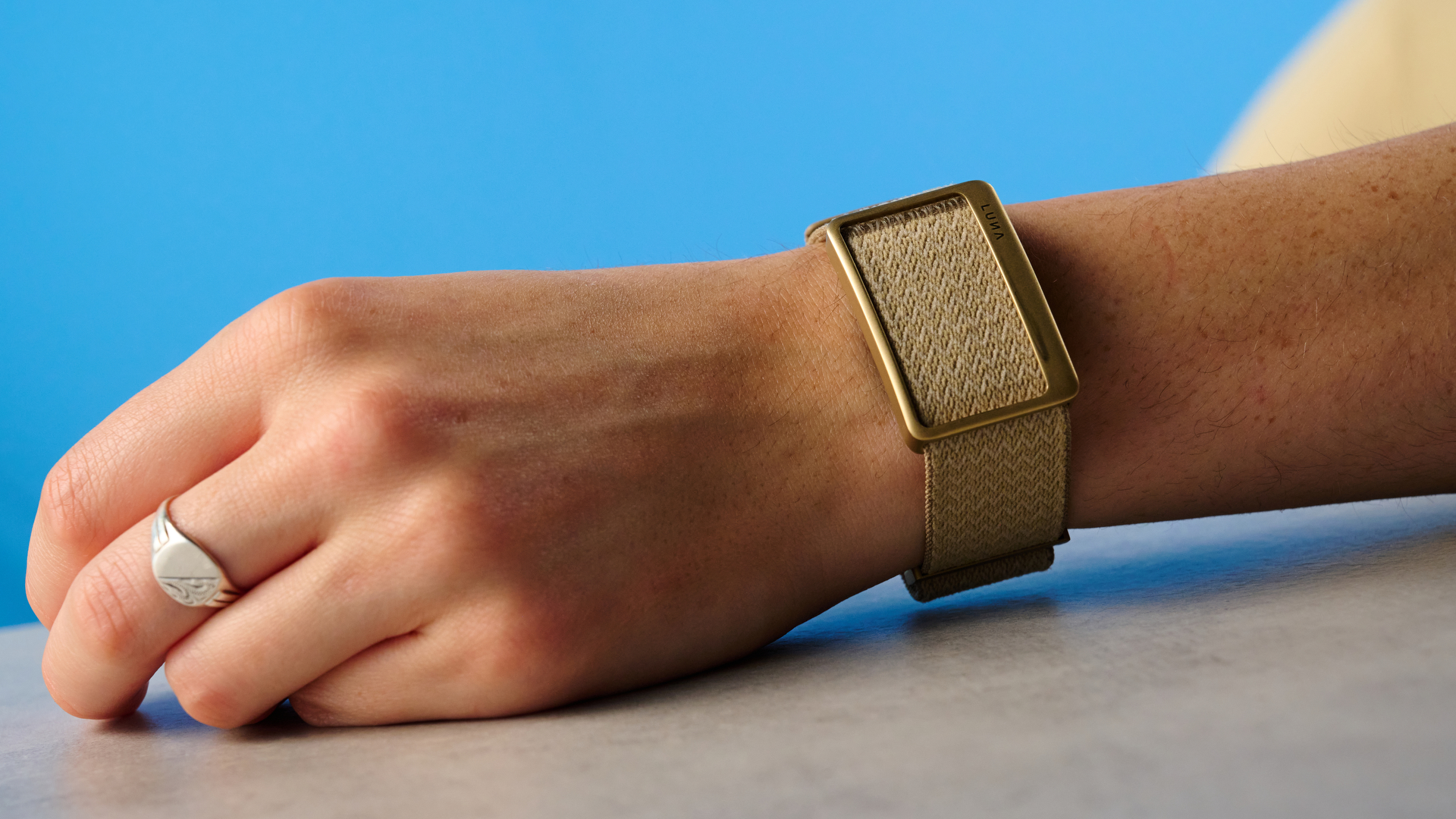the luna band in beige photographed with the blue tom's guide background being worn by the author
