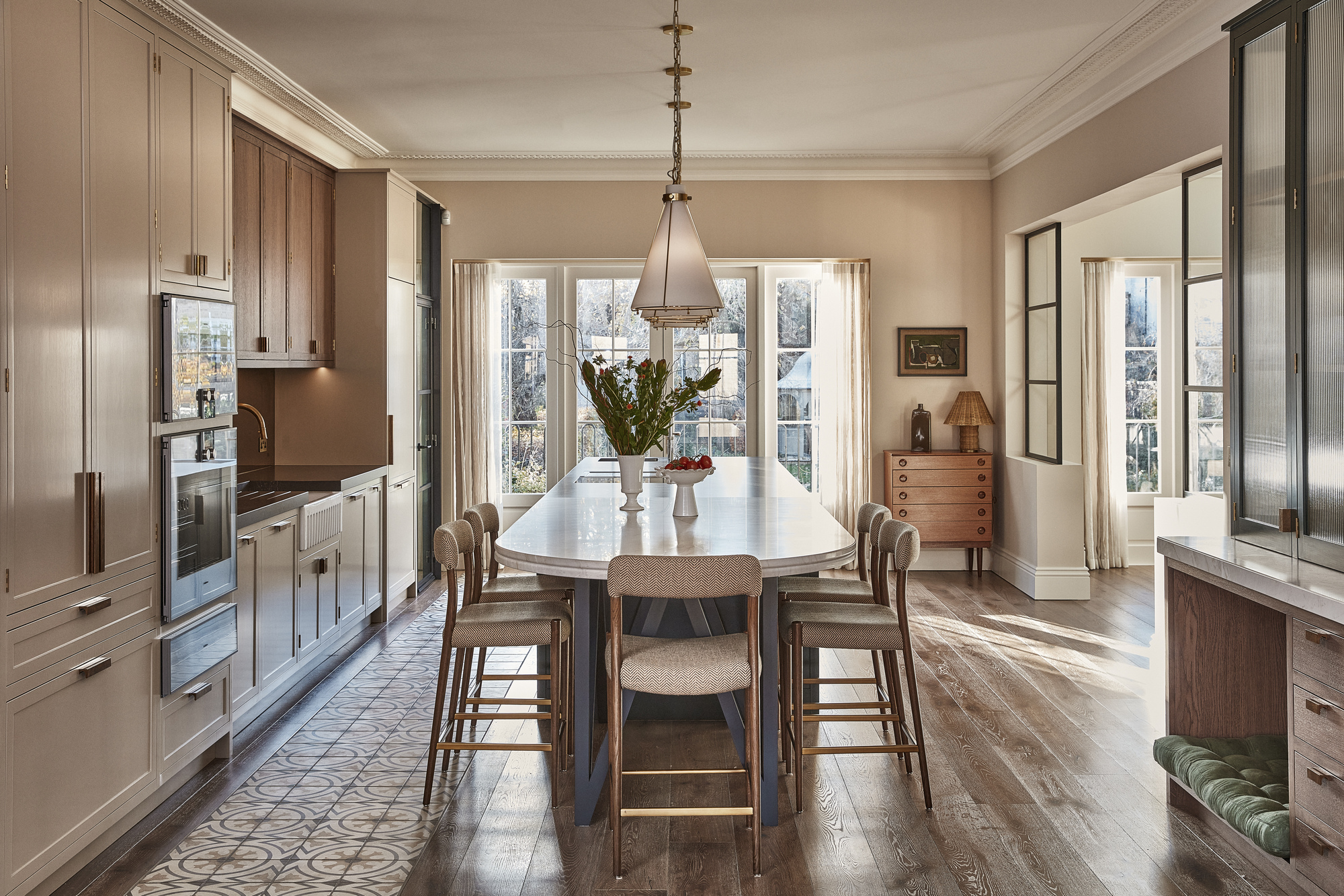 A one-wall kitchen with a dining a large table in the center of the room