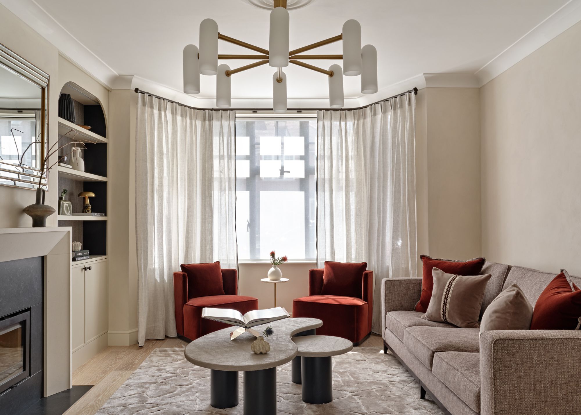 A living room with a grey sofa, and two red armchairs
