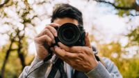 man using a camera out in nature
