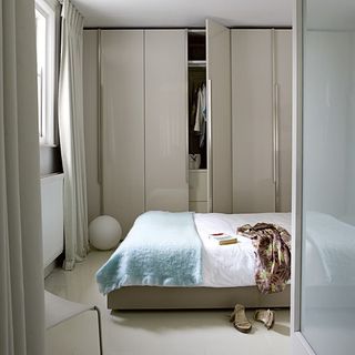bedroom with white cupboard and bed