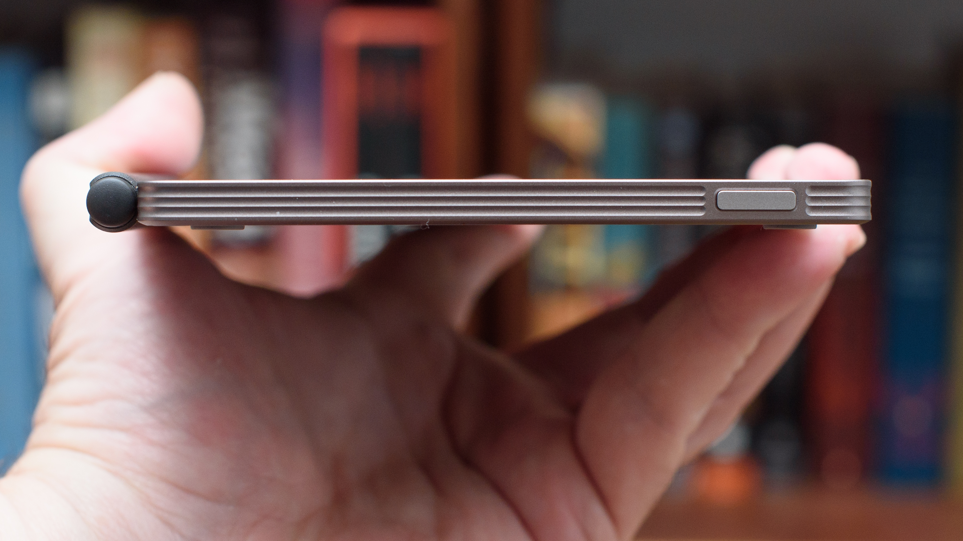reMarkable Paper Pro Move tablet in front of a library of books, showing various writing screens and comparing the size to a Moleskine notebook