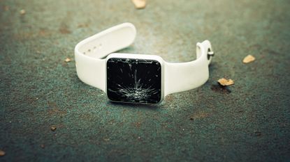 Broken smartwatch on the ground outdoors