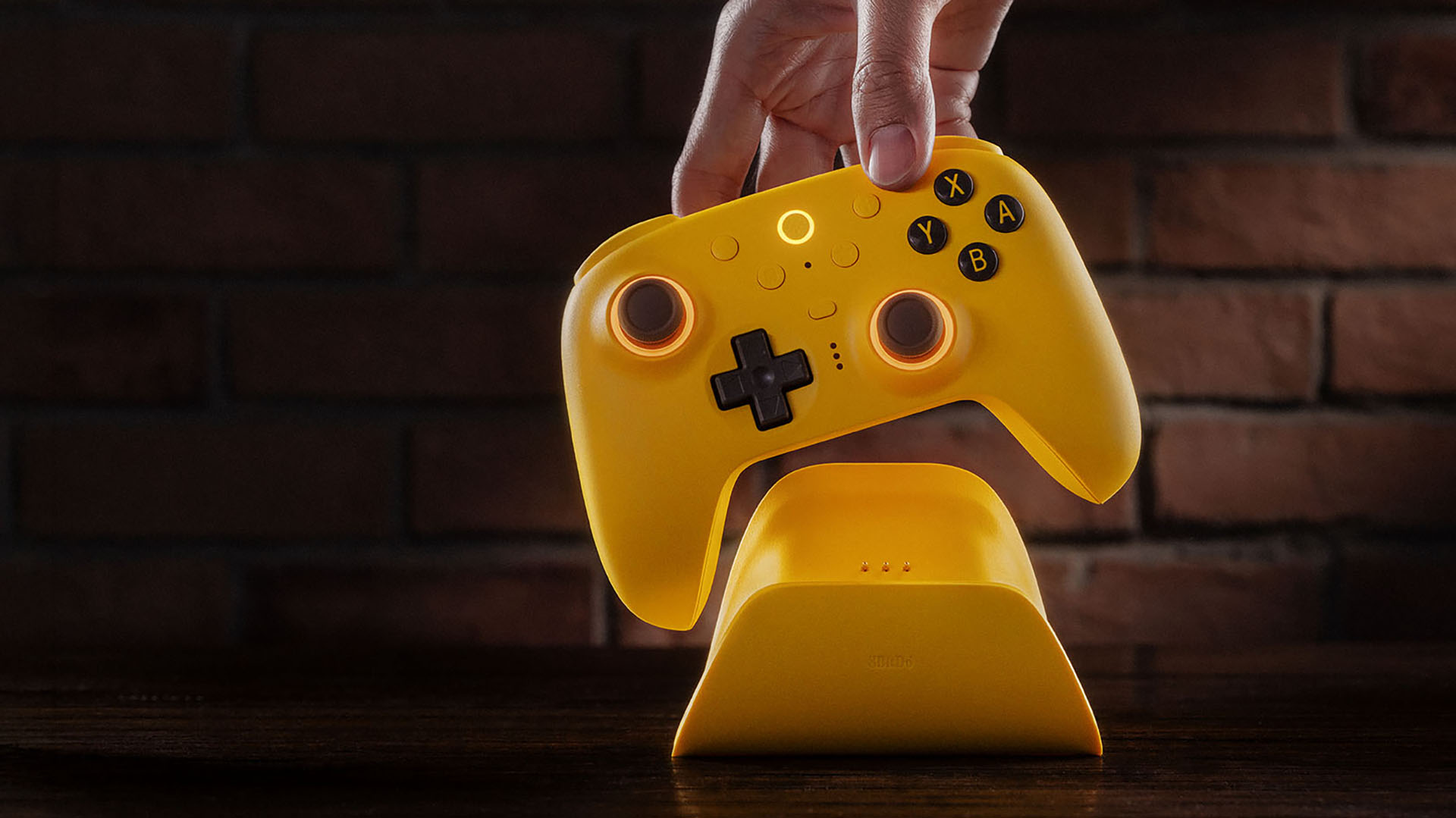 Yellow 8BitDo Ultimate 2 controller being placed on its charging dock