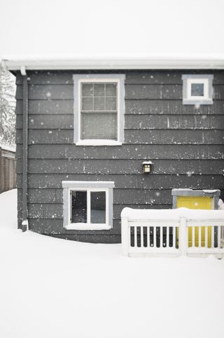 american house in winter with ice and snow