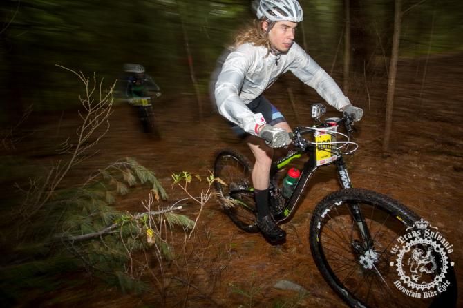 Mike Hebe rides through the green background under the precipitation of Stage 5