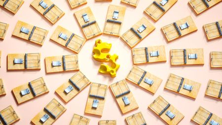 a yellow dollar sign that looks like swiss cheese is in the middle of circles of mouse traps