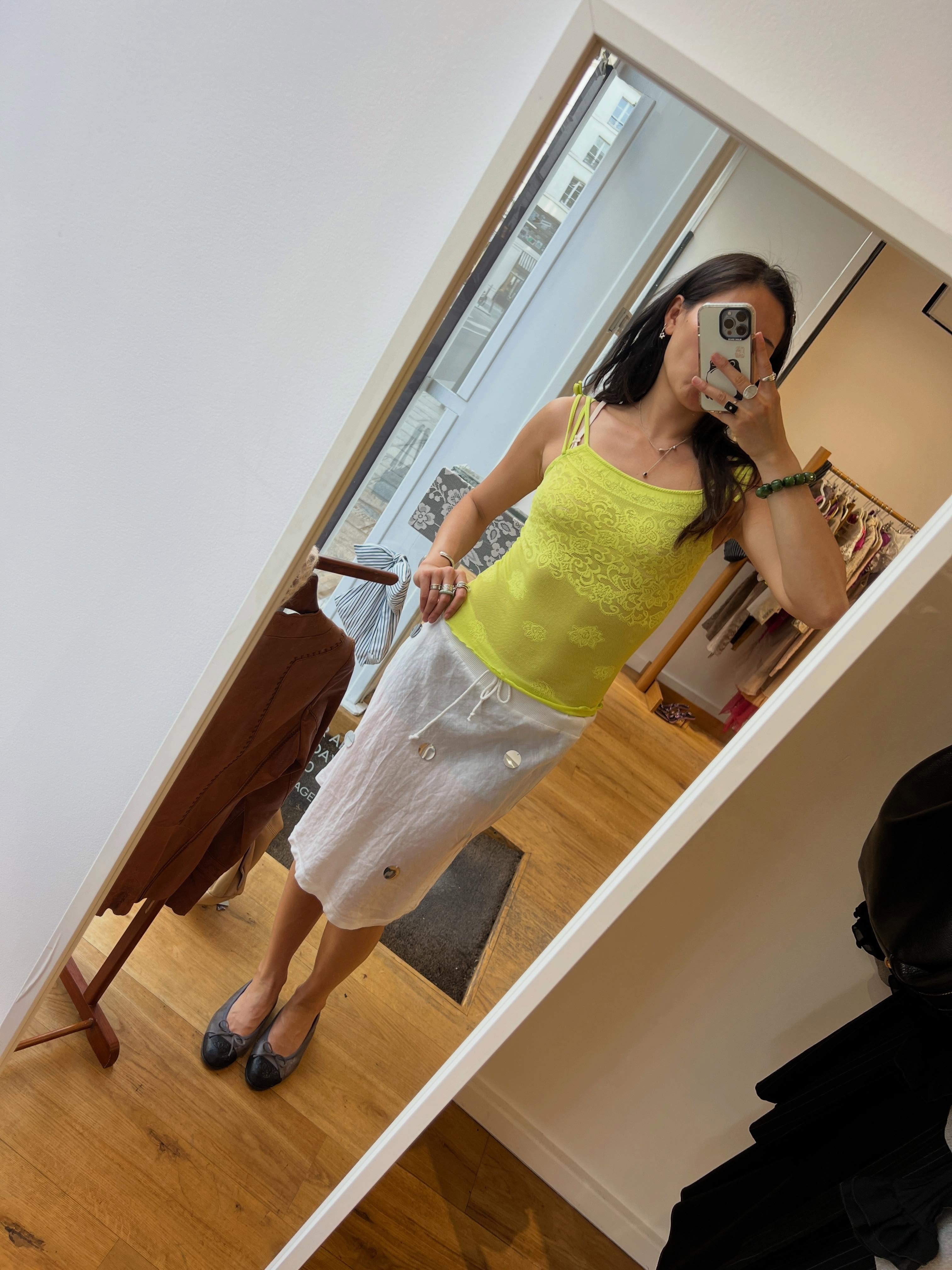 Woman in a camisole, slip skirt, and ballet flats.