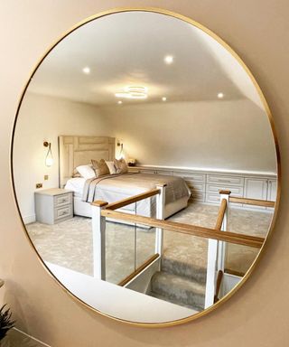 loft conversion bedroom reflected in circular mirror on wall