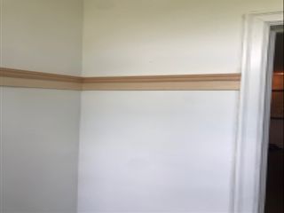 Process of DIY board and batten wall paneling with materials on white wall
