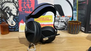 Meze Audio Empyrean II open-back headphones upright on wooden shelf