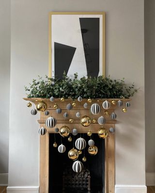 a fireplace with christmas ornaments strung from it