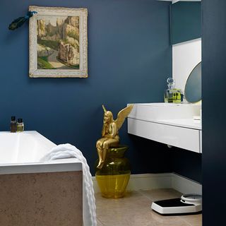 bathroom with painting on wall and dark navy blue wall with show piece and bathtub