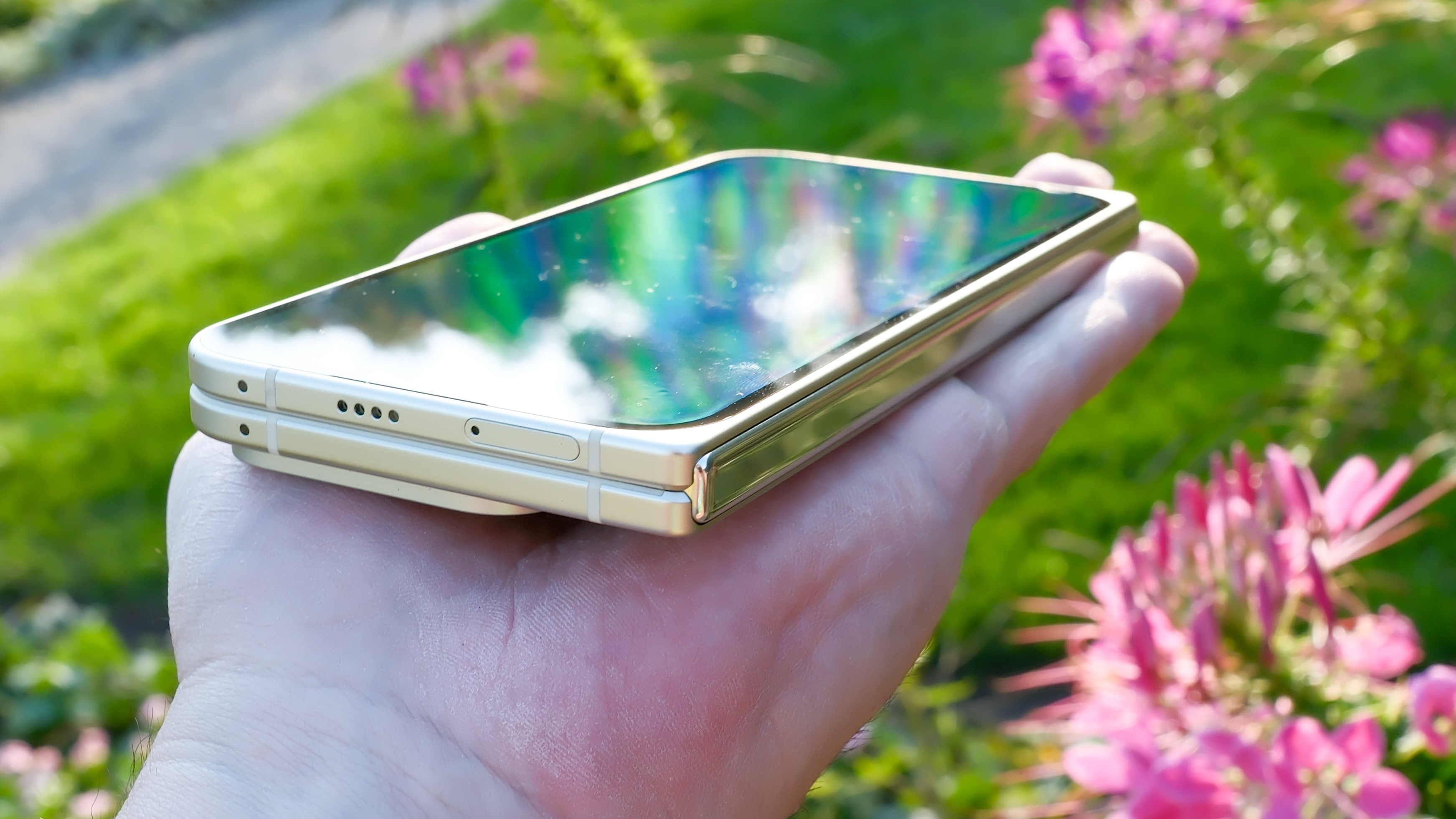 Google Pixel 10 Pro Fold in Jade green outside at a flower garden on a sunny day
