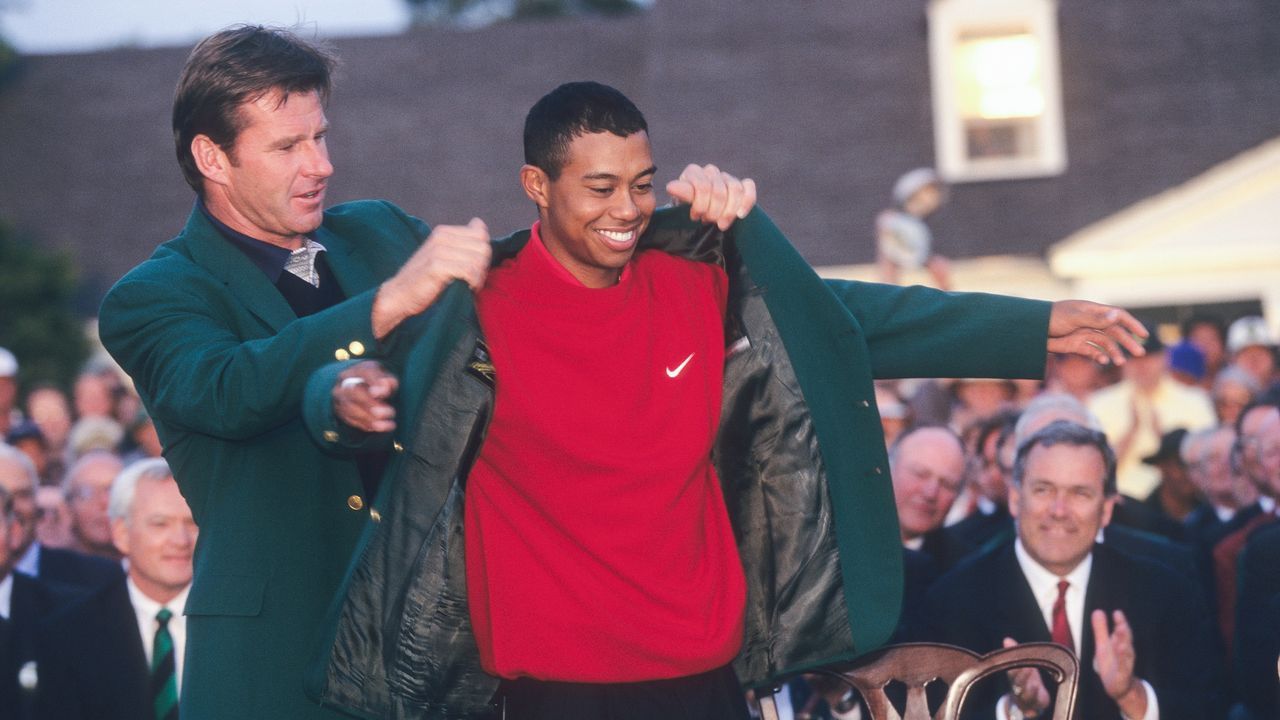 Tiger Woods receives the Green Jacket from Nick Faldo after winning the 1997 Masters