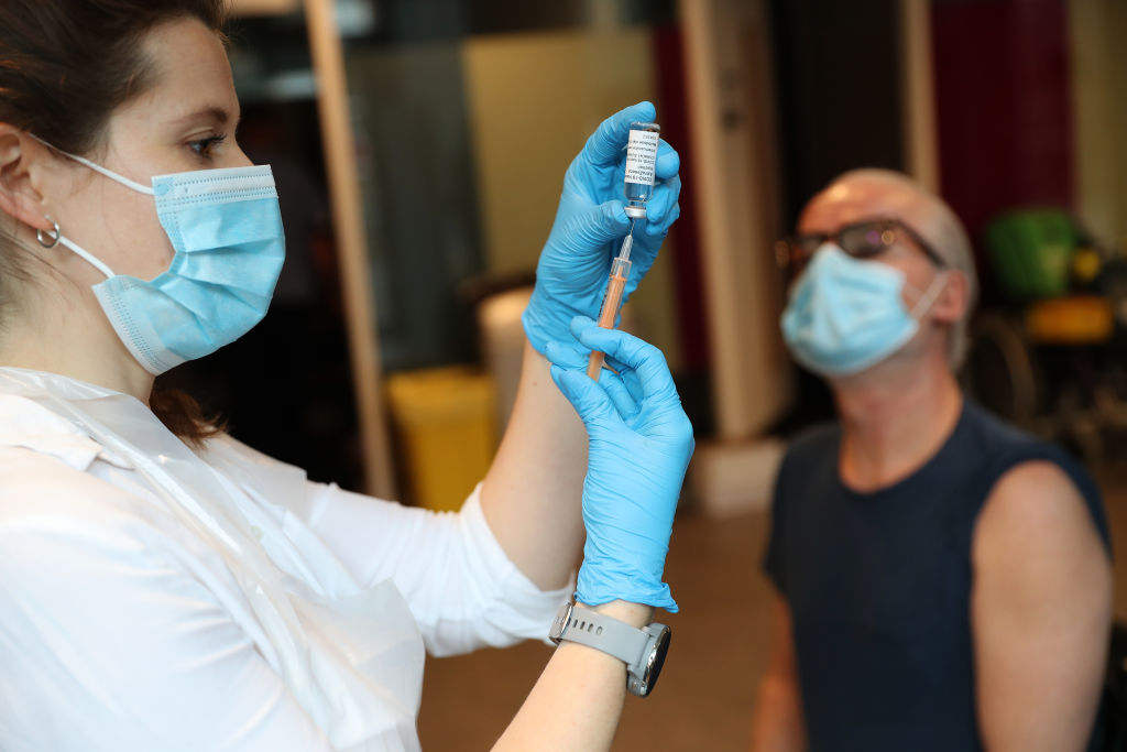 Woman delivering Oxford vaccine to man