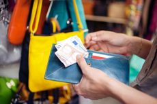 Young woman with travel money at San Lorenzo market, Florence, Tuscany, Italy