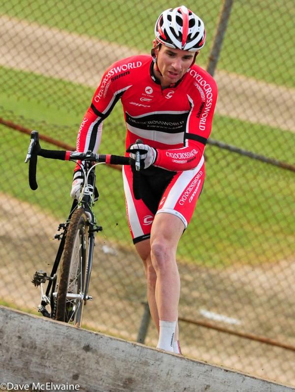 Dylan McNicholas (Cyclocrossworld.com) running the barriers on lap four