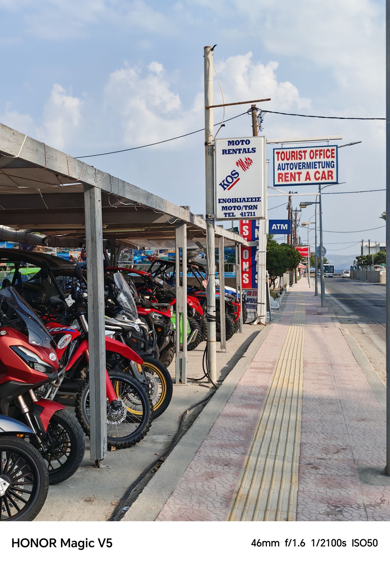 Motorbikes lined up in a garage at the side of the road ready for rental