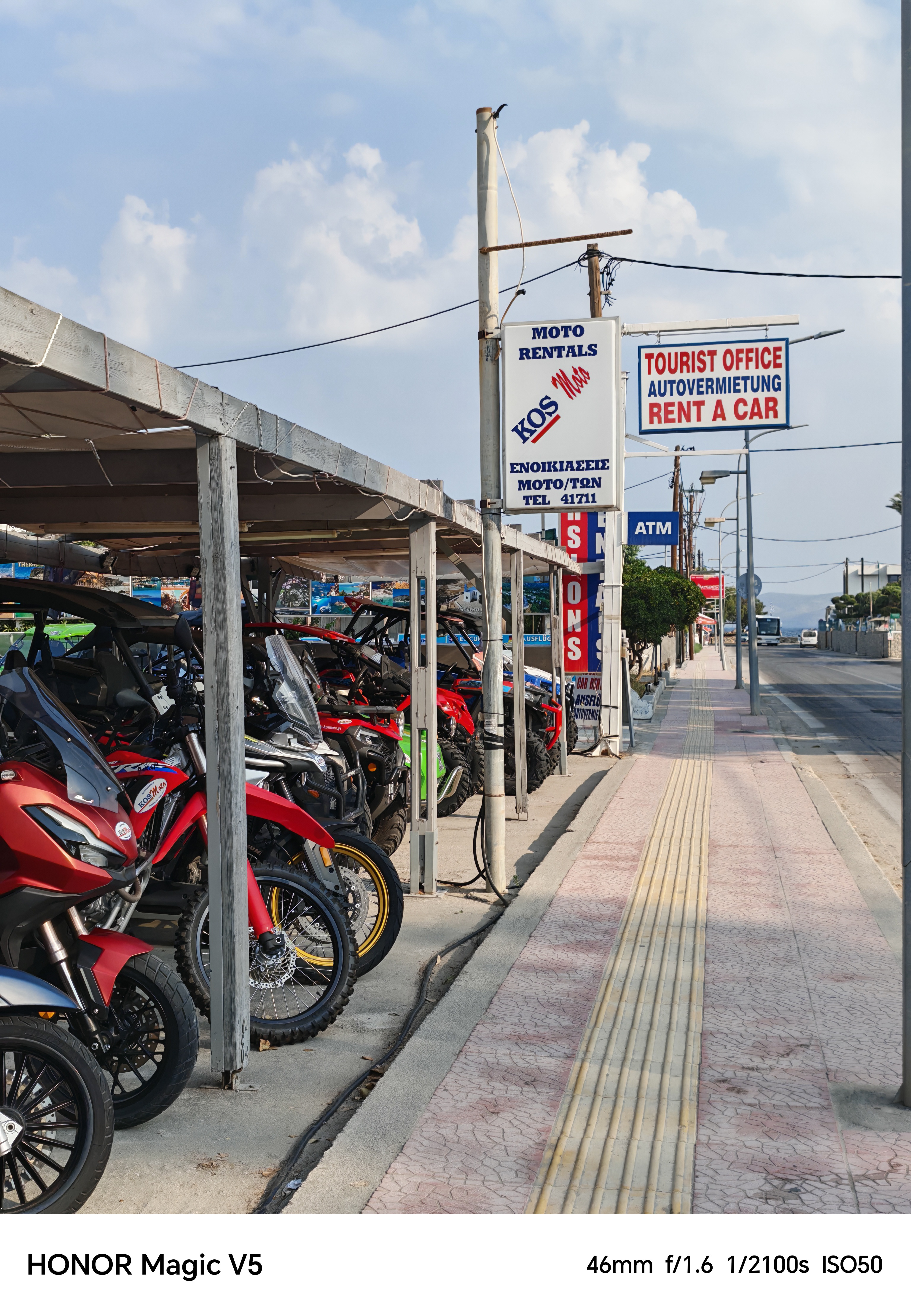 Motorbikes lined up in a garage at the side of the road ready for rental