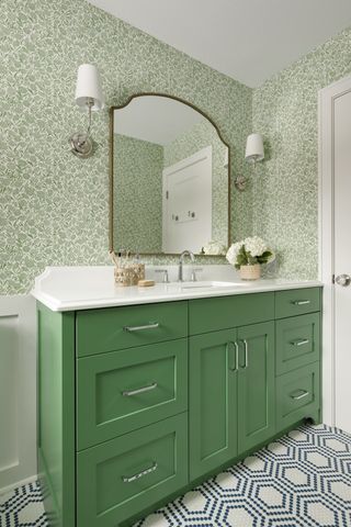 Green bathroom with floral wallpaper and blue tiled floor