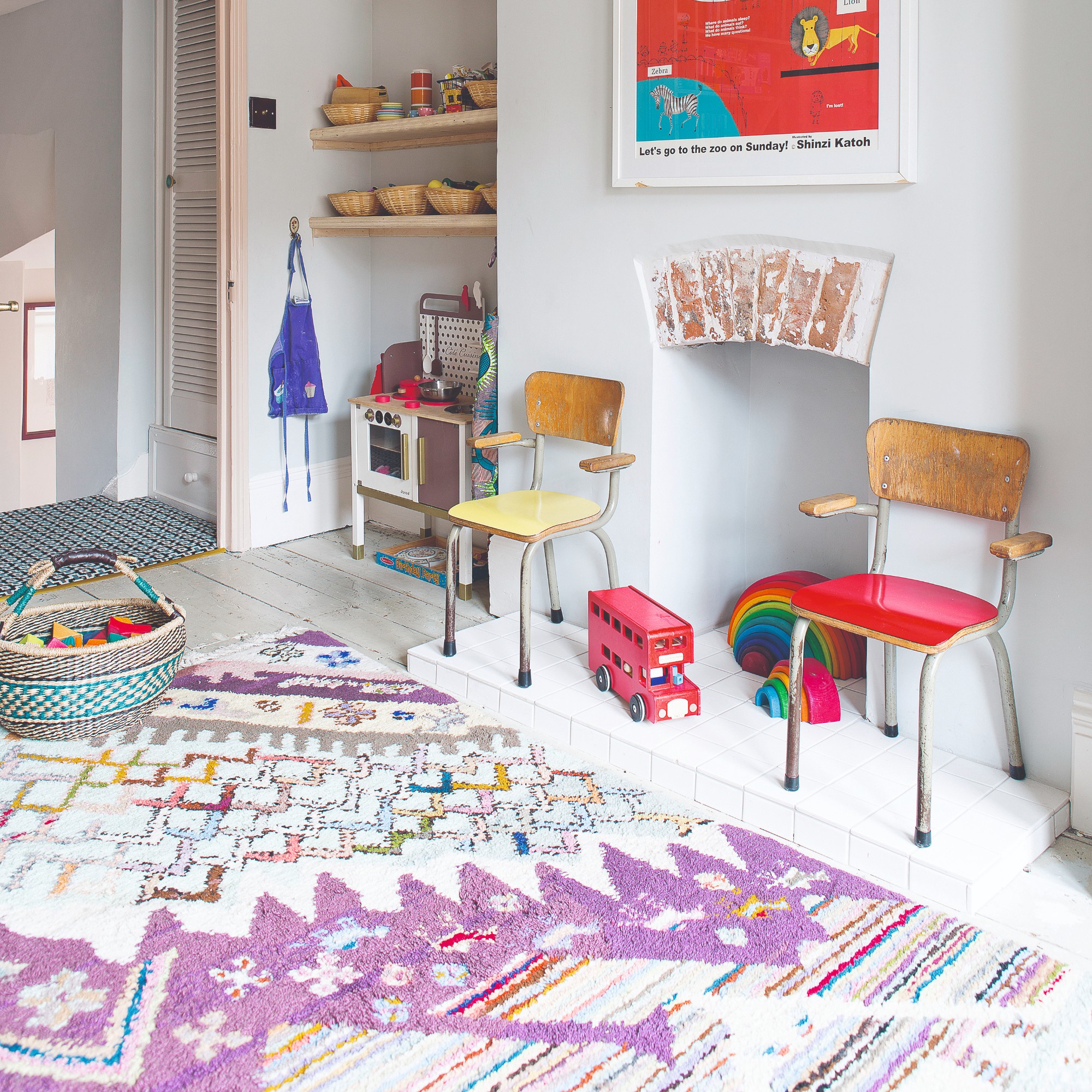 A playroom with a patterned colourful Berber-style rug and rattan baskets filled with toys