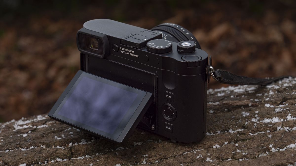 Leica Q3 Monochrom compact camera outside on a snow-dusted log