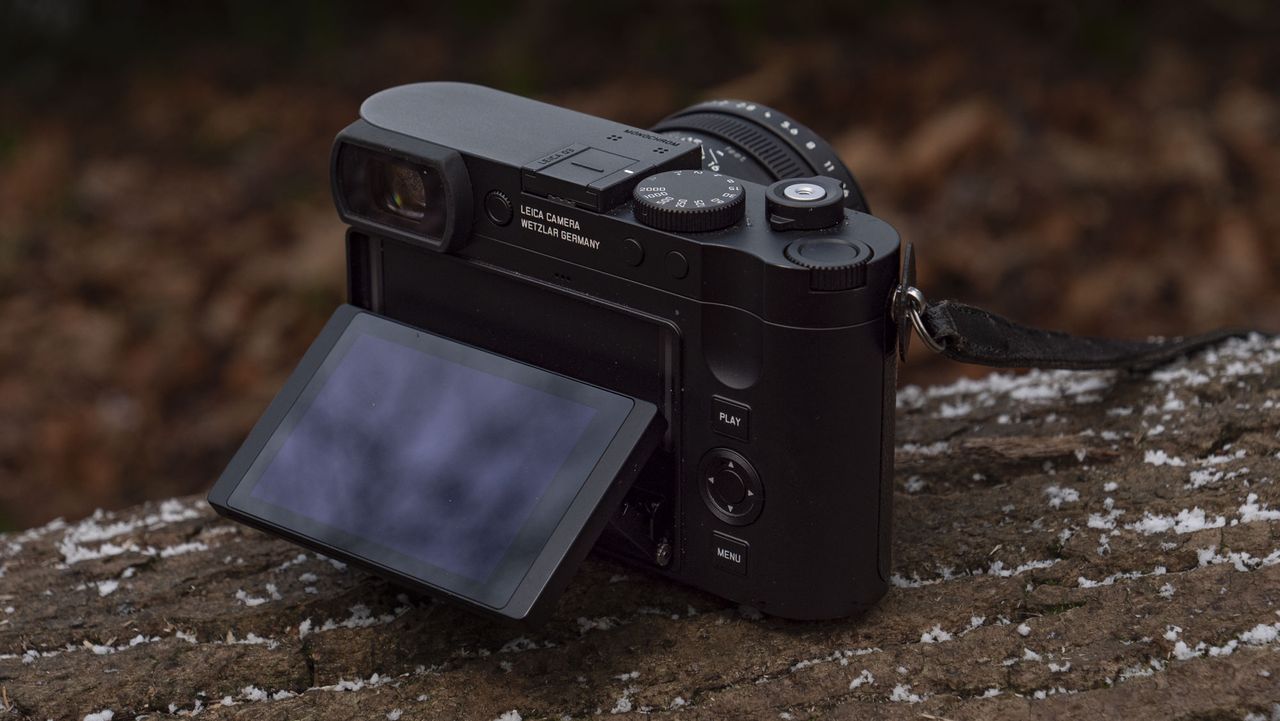 Leica Q3 Monochrom compact camera outside on a snow-dusted log