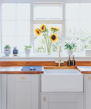 Modern, bright kitchen with an enamel sink and sunflowers
