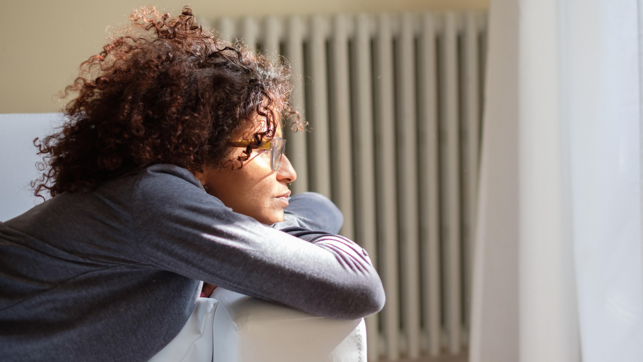 Woman looks out from sofa