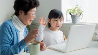 A child and their grandparent using a laptop to make a video call