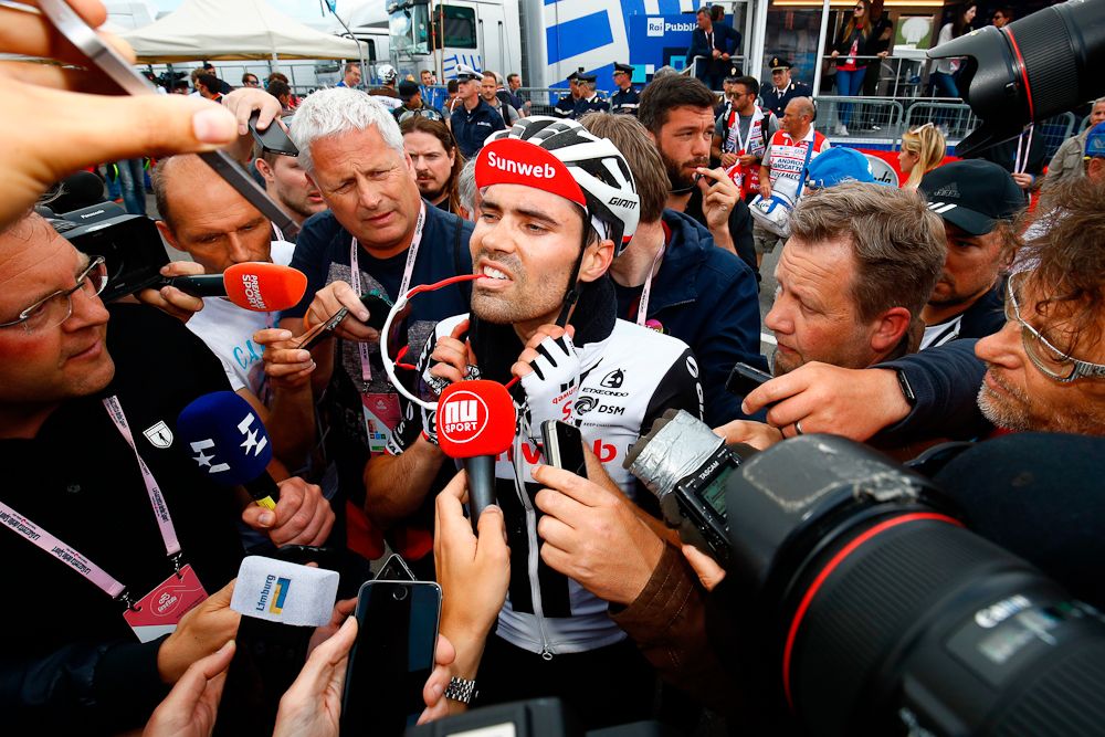 Tom Dumoulin is mobbed at the finish after cutting into Simon Yates' overall lead
