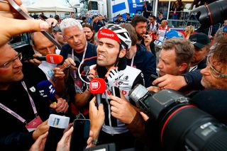 Tom Dumoulin is mobbed at the finish after cutting into Simon Yates' overall lead