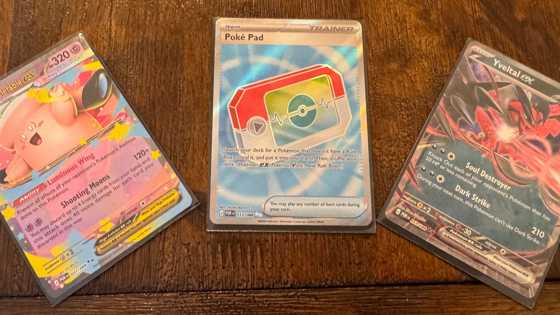 Pokemon Perfect Order cards on a wooden surface