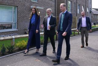 Prince William, Duke of Cambridge and Catherine, Duchess of Cambridge walk with Wheatley Housing Association's Graham Isdale (C) during a visit to the Wheatley Group