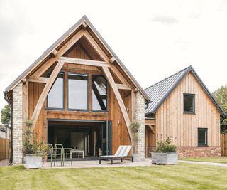 A double pitched roof design of an oak frame home. Two buildings are linked with a walkway